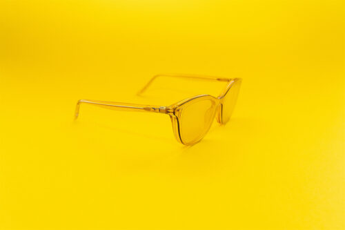 Transparente gelbe Brille auf einfarbig gelbem Hintergrund
