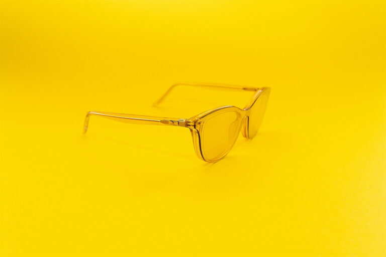 Transparente gelbe Brille auf einfarbig gelbem Hintergrund